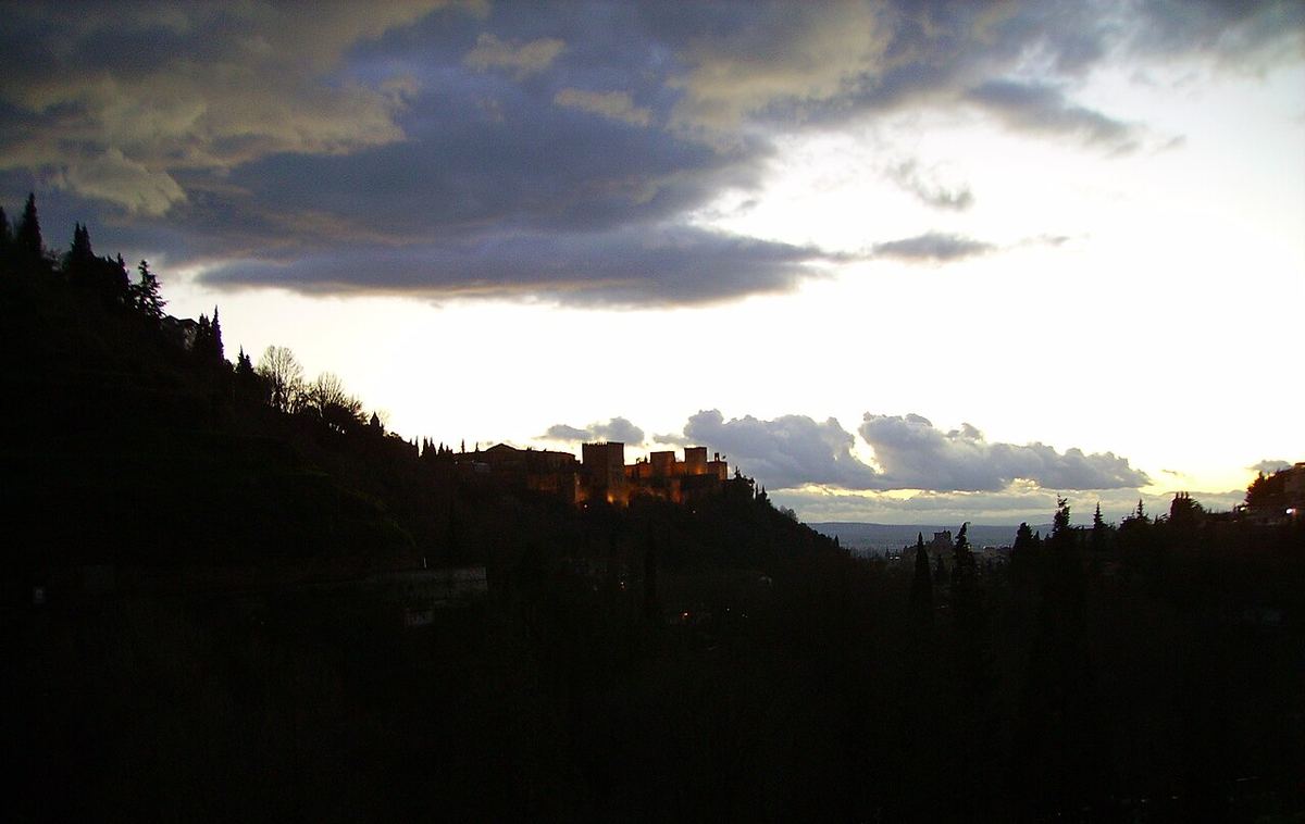 La Alhambra recortada al atardecer vista desde el Sacromonte, con el cielo encendido