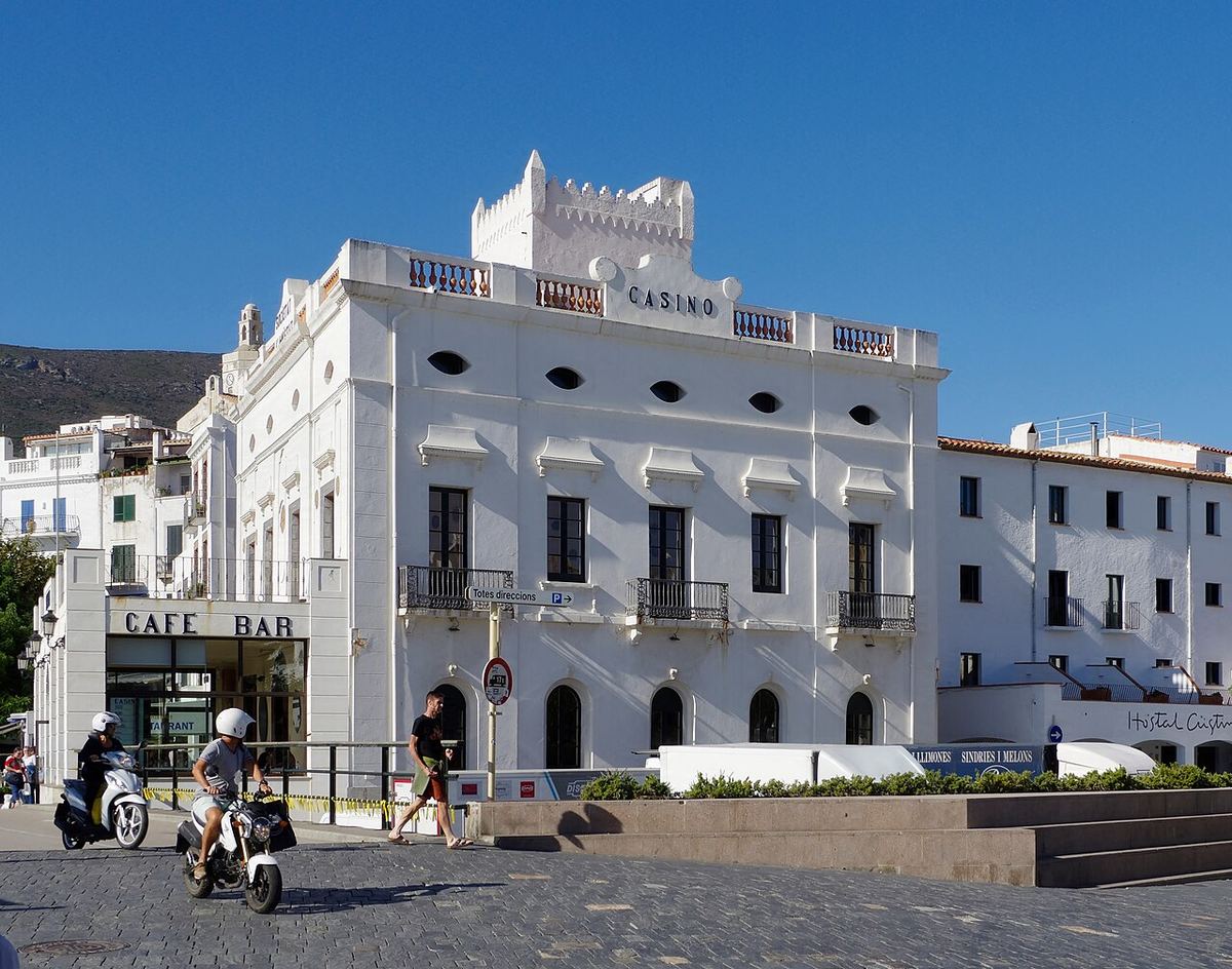 Plaza de Cadaqués con edificios blancos y motos aparcadas