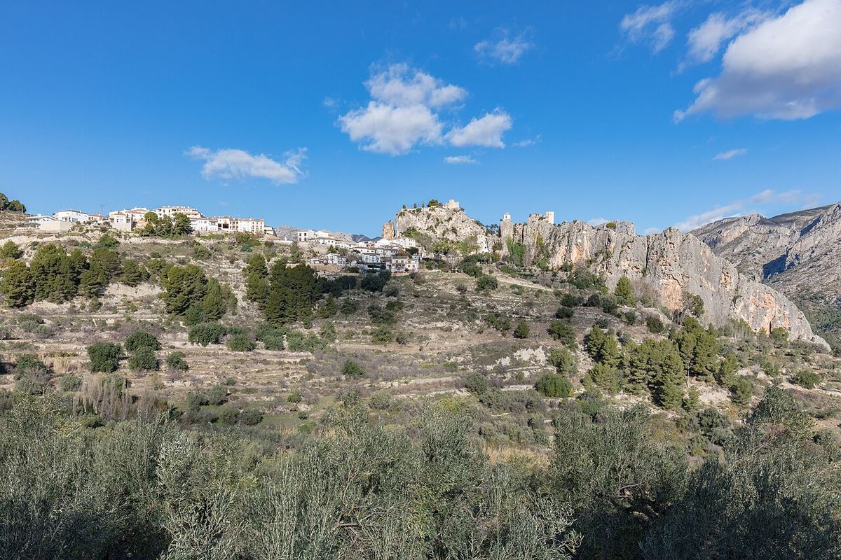 El pueblo de Guadalest encaramado en la roca con montañas alrededor