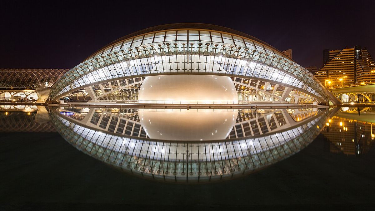 El Hemisfèric de la Ciudad de las Artes y las Ciencias iluminado de noche y reflejado en el agua
